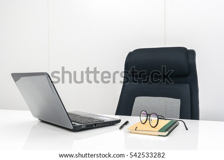 office desk with stationery notebook,on white table and black chair