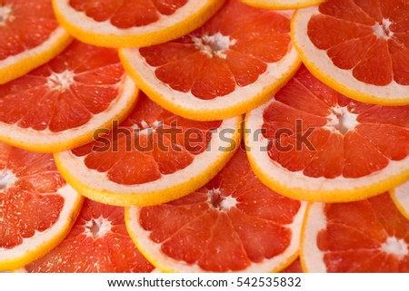 Bright red background with juicy slices of grapefruit. Healthy food background.
