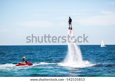 Silhouette of a fly board rider at sea Royalty-Free Stock Photo #542535853