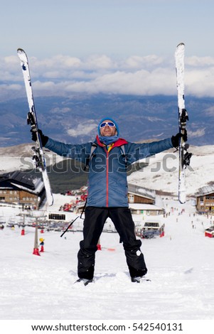 young happy man in winter clothes and ski gear posing happy in snow mountains at Sierra Nevada resort in Spain in adventure sport and vacation destination concept
