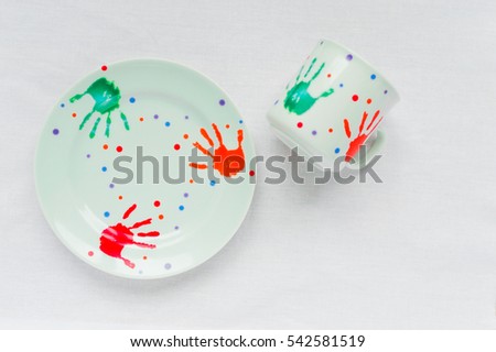 
one plate and one cup on a white background with a cheerful picture