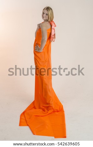 Young beautiful blonde woman in a bright orange fabric in a dress