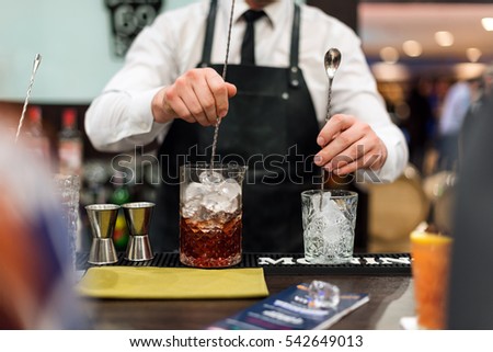Barman show. Bartender is making cocktail at night club Royalty-Free Stock Photo #542649013