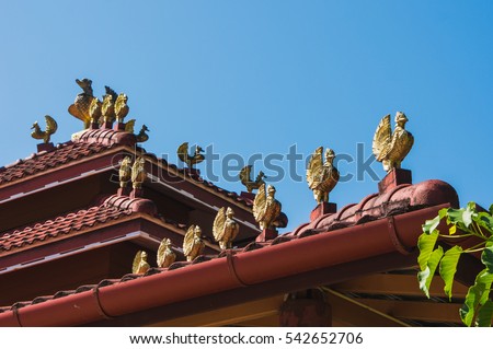 Golden bird statue on the red roof