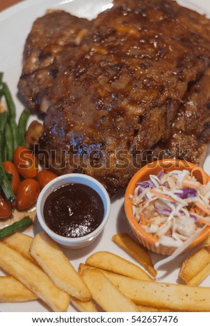 Succulent thick juicy portions of grilled fillet steak served with tomatoes and roast vegetables on white plate.