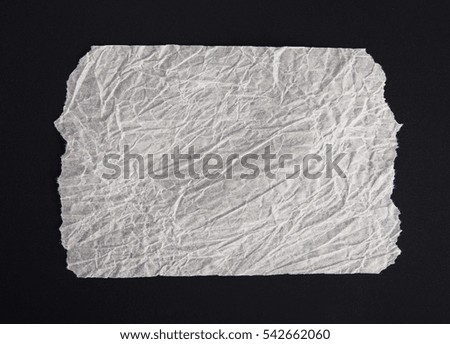 white kraft paper crumpled black background. torn edges paper