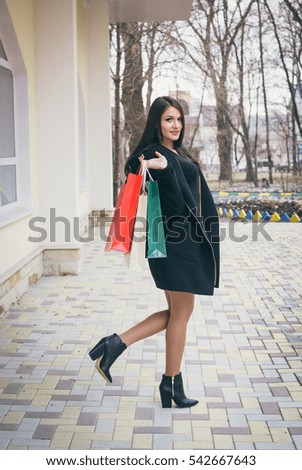 Young beautiful woman staying with bags after shopping