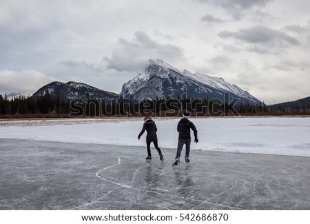 Couple skating on a frozen lake. Picture taken in Banff, Alberta, Canada.