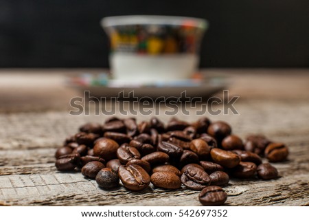 Coffee beans on front of picture and Ethiopian cup .Small depth of focus. Royalty-Free Stock Photo #542697352