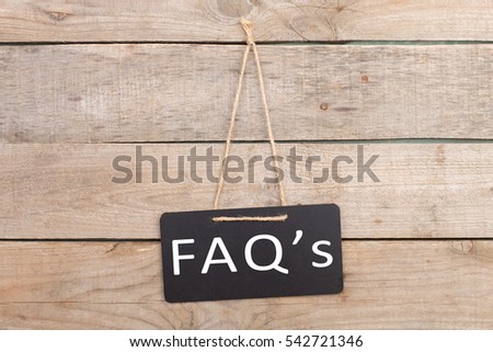 Blackboards with inscription "FAQ's" on wooden background Royalty-Free Stock Photo #542721346