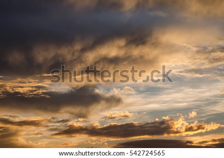 Menacing sunset sky with dark smoky clouds and azure