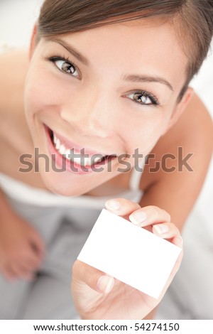 Cute woman holding business card. Beautiful mixed race Asian Chinese / Caucasian young woman in high angle view.