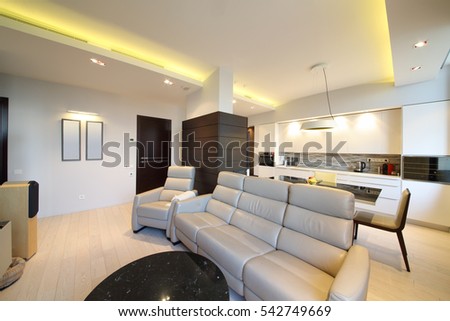Interior of modern room with a home theater in a recreation area in front of a dining area