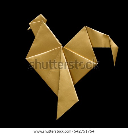 Shiny golden paper folded rooster handmade origami craft on black background isolated