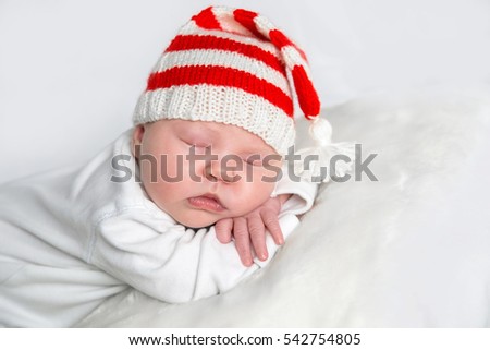 Newborn baby on white background in a Christmas Santa hat. A Christmas card. New year.