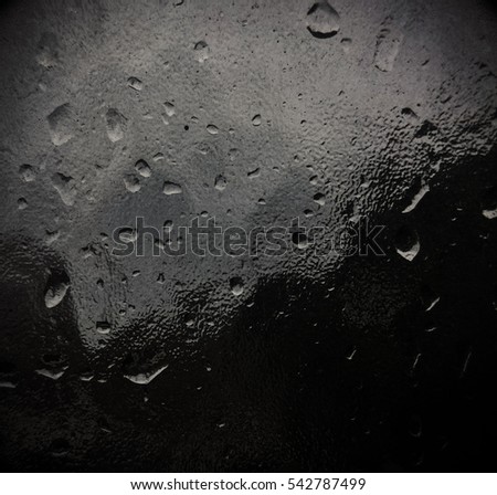 Raindrops on a frosted glass window.