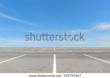 Empty parking lot on blue sky background Royalty-Free Stock Photo #542795467