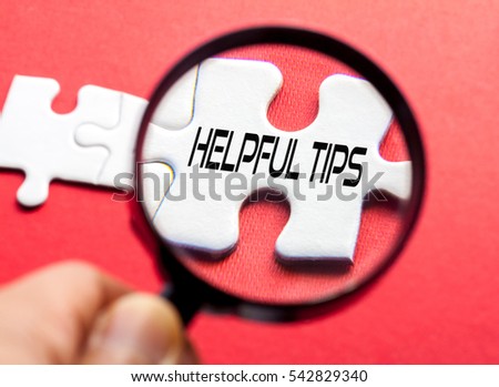 HELPFUL TIPS written on white puzzle with magnifier glass,conceptual