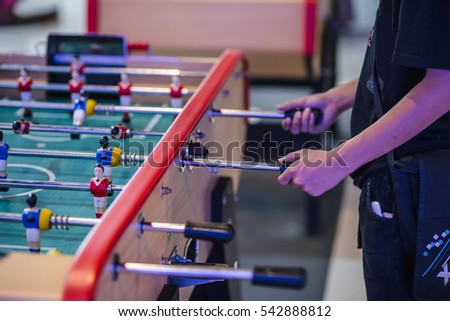 Detail of boy's hands playing the foosball table match. Concept photo of leading the company.