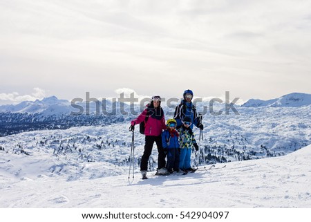 Young happy family with two children, boy brothers, skiing in Austrian ski resort on a sunny winter day