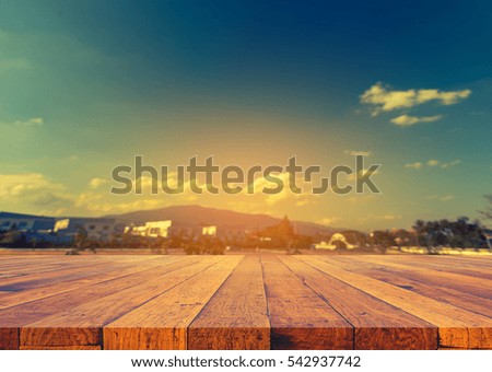image of wood table and blur house and cloudy blue sky for background usage.