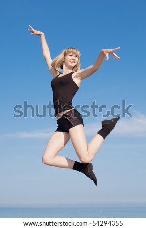 Slim girl dancing on background of sky