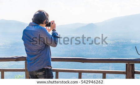 a man is taking a landscape photo.