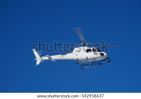 Helicopter flying against the blue sky.
