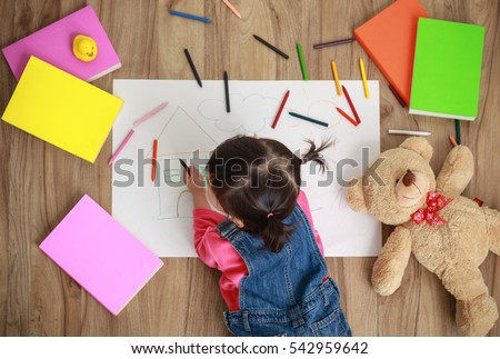 Adorable little girl drawing artwork, Studio shot top view on floor