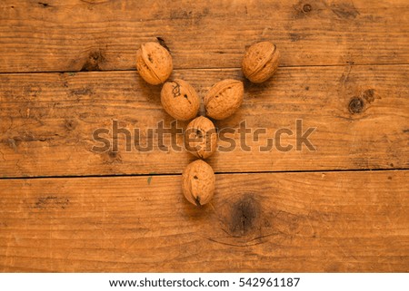 Color top view of english alphabet made from walnuts on a wooden table. Letter Q