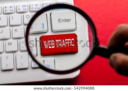 WEB TRAFFIC word written on keyboard view with magnifier glass