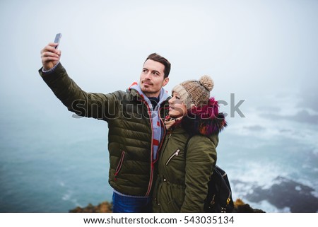 young couple making selfie by sea