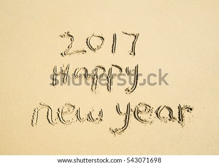 2017 happy new year written in sand write on tropical beach