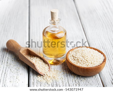 Sesame seeds and bottle with oil on a old wooden table Royalty-Free Stock Photo #543071947