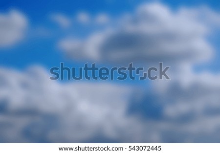 Background blur of fluffy white clouds in a bright bue sky