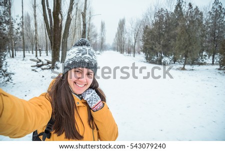 young woman making selfie in winter park