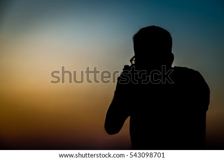 Siluate of man taking pictures before sunset background