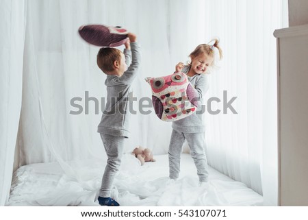 Children in soft warm pajamas playing in bed Royalty-Free Stock Photo #543107071