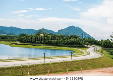 Green grass yard with lake, Thailand.