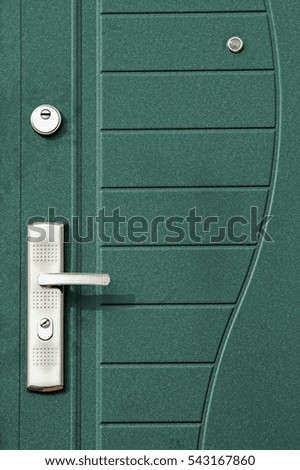 The surface of a metal door with lock and handle