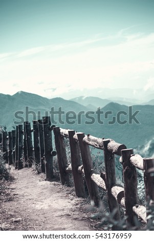 old wooden fence in a mountain meadow, vintage style picture 