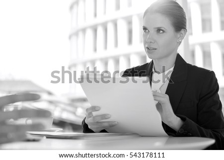 Businesswoman discussion paperwork with colleague in office cafeteria