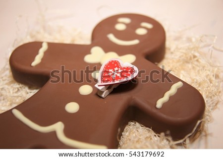 Figure  chocolate man decorated colored icing and being eaten. Holiday chocolate in shape of man for new year's day, christmas, winter holiday. Heart