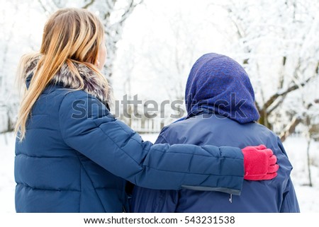 Picture of a caring young woman walking with her old grandmother