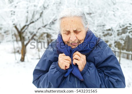 Picture of an old lady feeling cold on wintertime