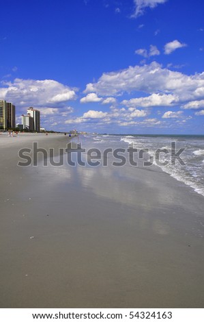 View of sand, sea, sky and surf on a pretty summer day perfect for cover art