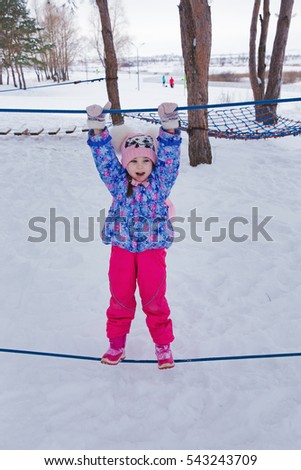 little 5 year old girl playing on the Playground in winter Park
