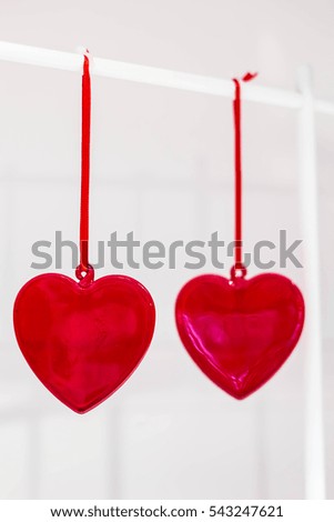two red glass hearts hanging on rope
