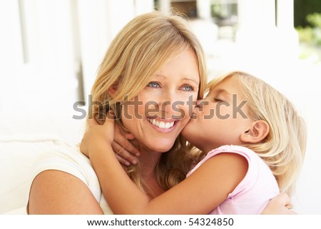 Daughter Giving Mother Kiss Relaxing On Sofa