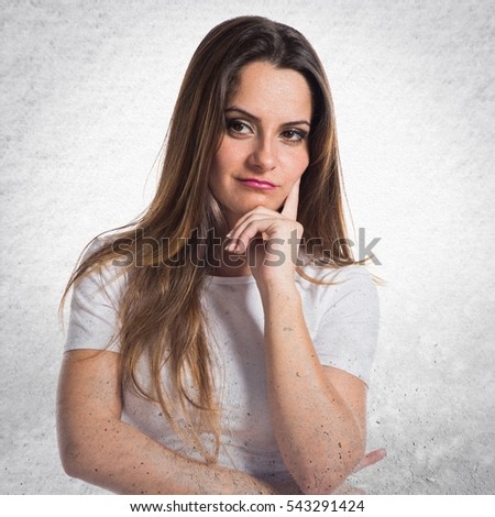 Young pretty girl thinking on textured background